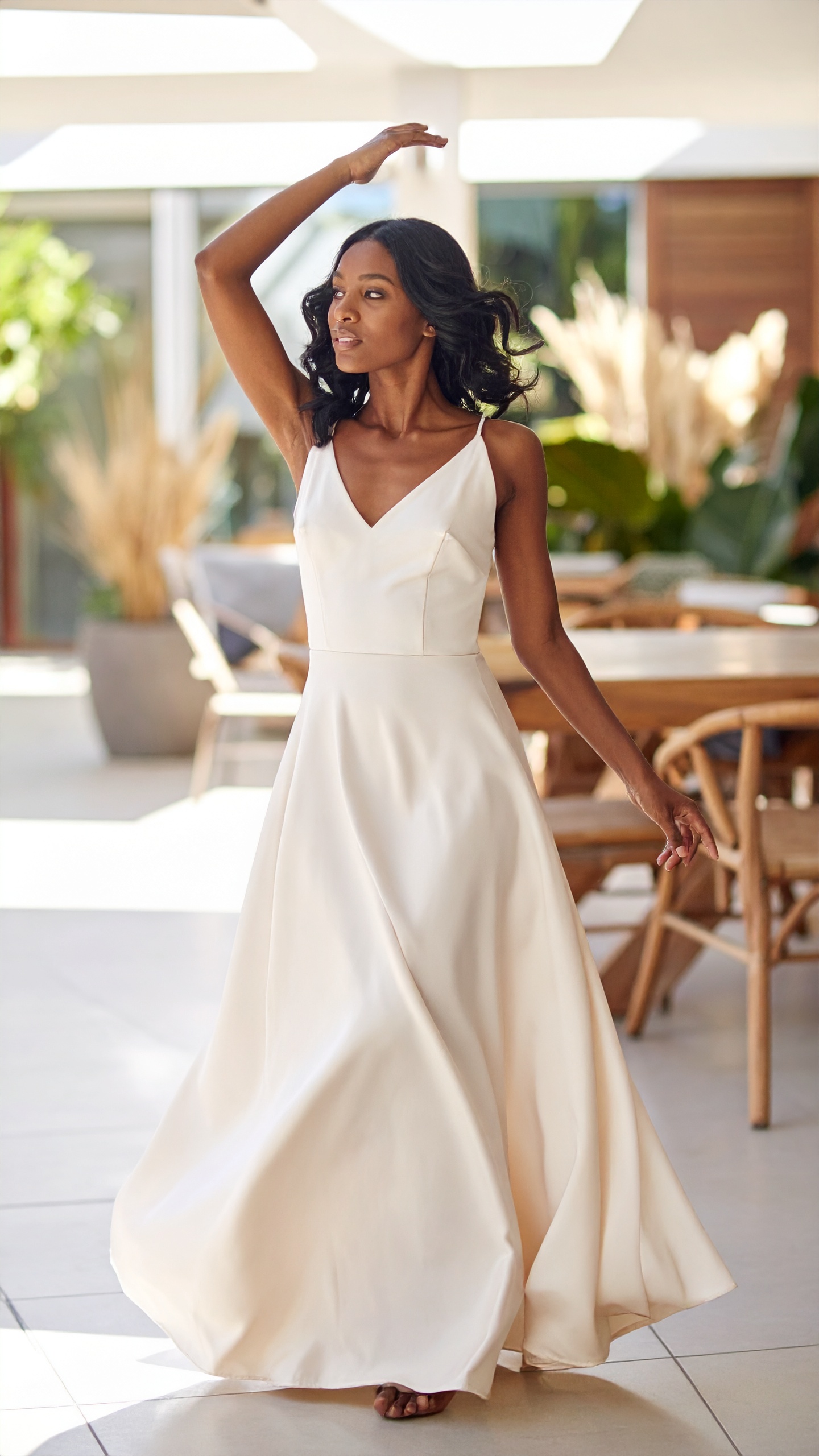 A woman in a pale gown in the middle of a turn, skirt carried wide